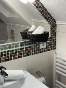 a bathroom with a sink and a mirror with towels at Hotel Schwanenweiher Bad Bertrich in Bad Bertrich +54 photos