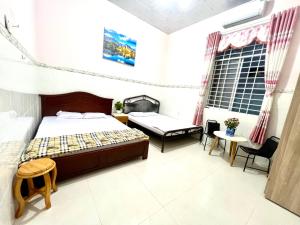a bedroom with a bed and a table and chairs at Khách Sạn Homestay LaMera in Ben Tre