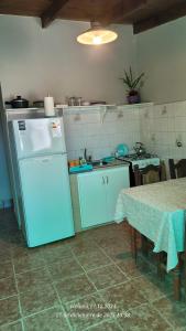 a kitchen with a blue refrigerator and a table with a tableablish at Depto Nacho in San Antonio Oeste