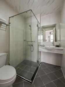 a bathroom with a shower and a toilet and a sink at Quy Hung Hotel And Spa Central in Ho Chi Minh City +31 photos