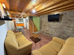 a living room with a couch and a stone wall at A Casa de Feli in Muros