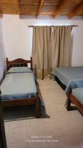 a bedroom with two beds and a curtain at Depto Nacho in San Antonio Oeste
