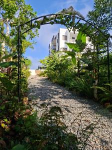 an archway over a gravel road with a building in the background at cacao resort las taranas in Villa Riva
