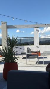 a patio with two potted plants and a table and benches at Sol del Valle in Mina Clavero +8 photos