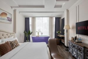 a hotel room with a bed and a television at Quy Hung Hotel - Ben Thanh Market in Ho Chi Minh City