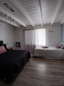 a bedroom with two beds and a large window at Chiche del mar in Playa Unión
