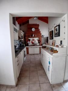 a kitchen with white cabinets and a tile floor at Chiche del mar in Playa Unión +3 photos