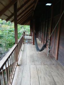 a porch with a hammock hanging from a building at Cabaña los Termales in Nuquí +12 photos