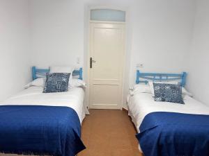 two beds in a room with blue and white at Casa Rural Eufemia in Arenales de San Gregorio +62 photos