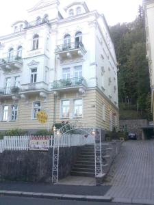 a large white building with stairs in front of it at Pension Villa Anita in Mariánské Lázně