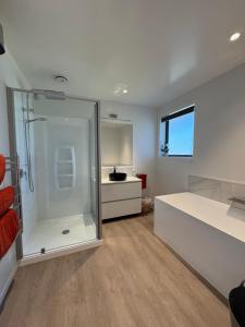 a large bathroom with a shower and a sink at Red Tussock Motel in Te Anau +116 photos