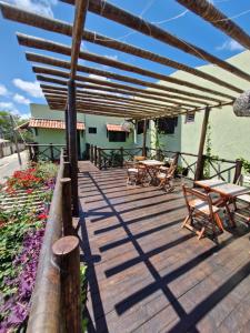a wooden deck with tables and chairs on it at Pousada Dunas Natal in Natal