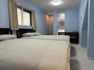 two beds in a room with a window at Style Room in Osaka