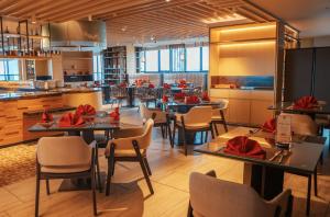 a restaurant with tables and chairs and a kitchen at Palm Springs Hotel Dili in Dili