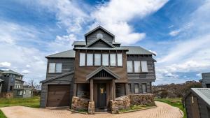 a black house with a gambrel roof at Camelot in Dinner Plain