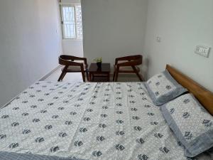a bedroom with a bed and two chairs and a table at R Square Homes in Bangalore