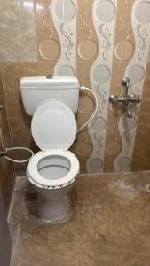 a bathroom with a white toilet in a stall at R Square Homes in Bangalore