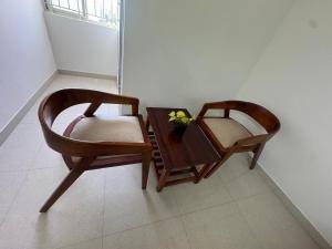 two chairs and a table with a vase of flowers on it at R Square Homes in Bangalore