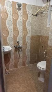 a bathroom with a shower with a toilet and a sink at R Square Homes in Bangalore