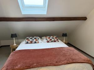 a bedroom with a bed with two lamps and a window at Cottage in the heart of the Ardennes in Waimes