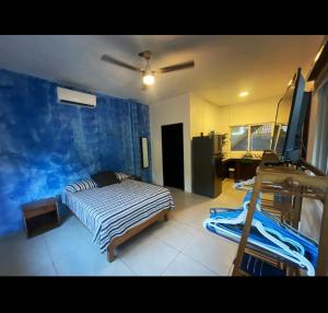 a bedroom with a bed and a blue wall at Casa Yolotli in Zipolite