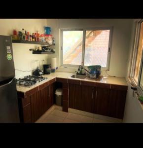 a kitchen with a sink and a stove and a window at Casa Yolotli in Zipolite