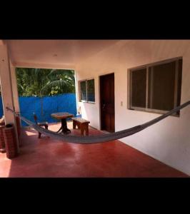 a hammock in a room with a table and a bench at Casa Yolotli in Zipolite