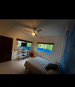 a bedroom with a bed and a ceiling fan at Casa Yolotli in Zipolite