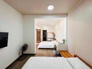 a bedroom with two beds and a tv at Leranda Bonita in Hue