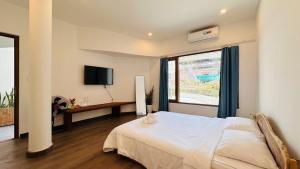 a bedroom with a bed and a window and a desk at Leranda Bonita in Hue