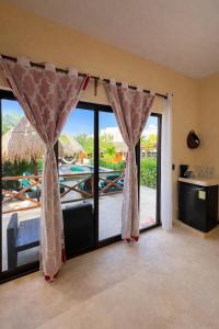 a room with sliding glass doors with a view of a pool at Atenea - Optional Beach Club in Holbox Island