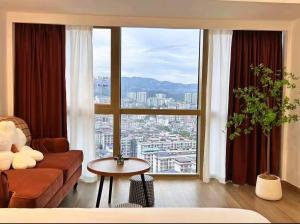 a living room with a couch and a large window at Macaron in Zhangjiajie