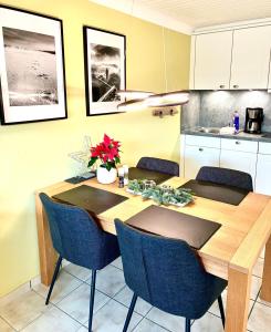 a dining room with a wooden table and blue chairs at Ritas-Op-Soelring in Westerland +9 photos