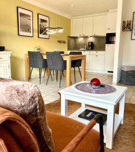 a living room with a table and a kitchen at Ritas-Op-Soelring in Westerland