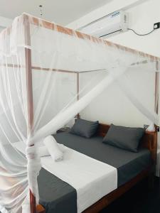 a bed with a canopy in a room at silent beach House For Ever in Tangalle