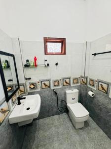 a bathroom with a white toilet and a sink at silent beach House For Ever in Tangalle