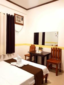 a room with two beds and a table and chairs at Villa Monica Hotel in Balatero