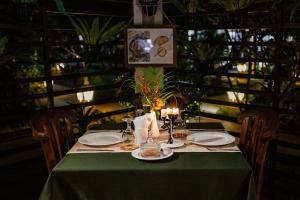 a table with a green table cloth and candles on it at Rossa Garden Hotel Boutique in Candidasa