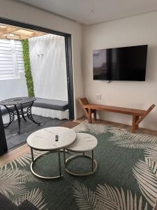 a living room with two tables and a flat screen tv at Two Tides in Ballito