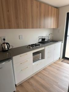 a kitchen with white cabinets and a stove top oven at Two Tides in Ballito