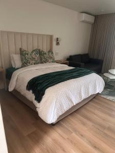a bedroom with a large bed with a wooden floor at Two Tides in Ballito