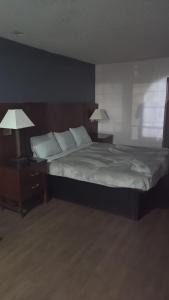 a bedroom with a large bed with two night stands and two lamps at King Bed Hotel Room 251 in Jackson