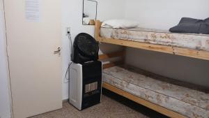 a room with a clock next to a bunk bed at Hostel El Refugio de Las Aves in Santa Rosa de Calamuchita