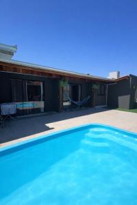 a blue swimming pool in front of a house at Apartamento 03 - Refúgio do Descanso in São Francisco do Sul +7 photos