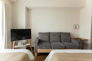 a living room with a couch and a flat screen tv at Planetarium N in Yamashitachō