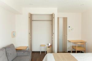a bedroom with a bed and a couch and a table at Planetarium N in Yamashitachō