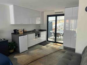 a kitchen with white cabinets and a dining room at Three Waves in Ballito
