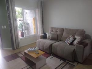 a living room with a couch and a coffee table at Casa aconchegante e completa em Osório - Ótima localização in Osório