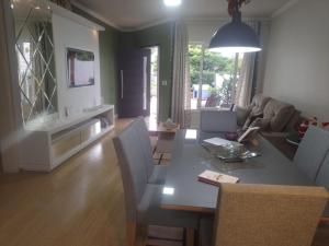 a dining room and living room with a table and chairs at Casa aconchegante e completa em Osório - Ótima localização in Osório