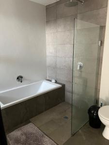 a bathroom with a bath tub and a toilet at Three Waves in Ballito
